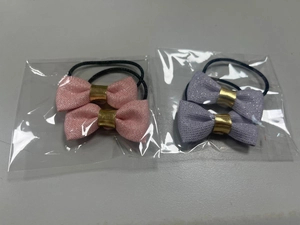 Detail of glitter bow hair ties with gold center clasp and black elastic bands