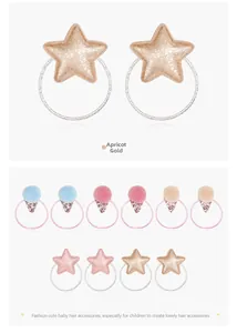 Detail of glitter star and pompom hair ties with metallic elastic bands in apricot gold
