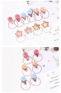 Detailed view of children colorful star and pompom elastic hair ties with glitter accents
