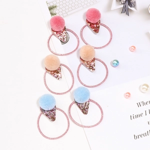 Three pairs of glitter star and pom pom earrings in pink, blue, and orange colors