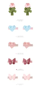 Detalle de horquillas de lazo rosa y clips de corazón tejido con perlas para niñas