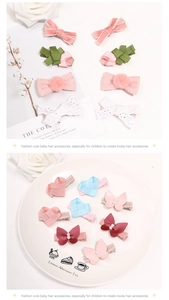 Detalle de lazos de cinta rosa y horquillas de corazón con perlas falsas en un plato