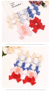 Détail de barrettes à nœuds en satin coloré avec pompons en fausse fourrure pour filles