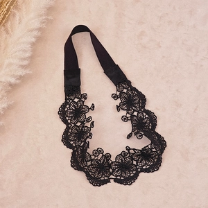 Close-up of black hollow lace floral headband with elastic band and embroidery details
