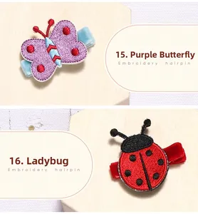 Détail de barrettes brodées papillon violet et coccinelle rouge avec tissu velours