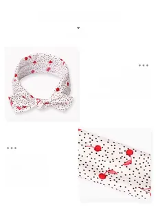 Detailed close-up of cherry pattern bow headband with black polka dots for babies