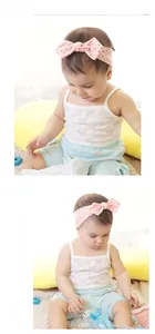 Detailansicht eines Baby-Stirnbands in Rosa mit schwarzen Punkten und großer Schleife