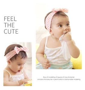Nahaufnahme von rosa Baby-Stirnband mit schwarzen Punkten und süßem Schleifen-Design