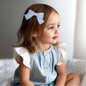 Gros plan d'une jeune fille portant une pince à cheveux avec nœud en tissu bleu clair