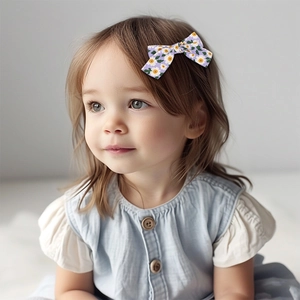 Gros plan d'une petite fille portant une barrette nœud violette à motifs marguerites