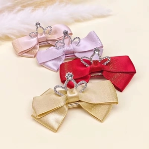 Détail de barrettes à nœuds en satin colorés avec ornements de couronne en strass