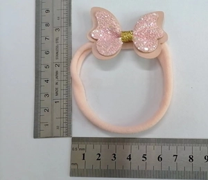 Detailaufnahme einer rosa Pailletten-Schleife mit Maßband zeigt Größe von 6,5 cm