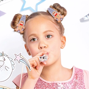 Detail showing young girl wearing purple glitter snap clips with gingerbread man design