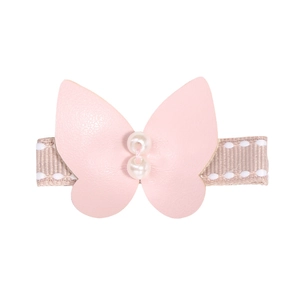 Detailed macro view of handmade pink leather butterfly clip with dual pearls and polka dot ribbon