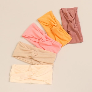 Detailed view of soft modal baby headbands in five warm pastel colors with knotted design