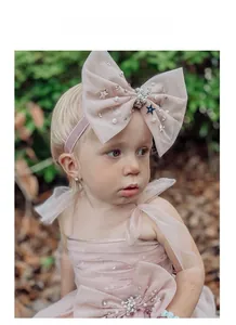 Détail du bandeau pour bébé en tulle rose clair avec étoiles argentées et perles
