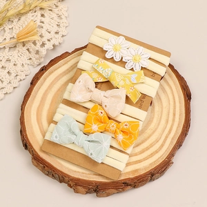 Détail de cinq bandeaux pour bébé avec nœuds et fleurs sur un support en bois