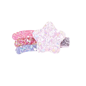 Détail d'une pince à cheveux étoile en paillettes roses et violettes pour filles
