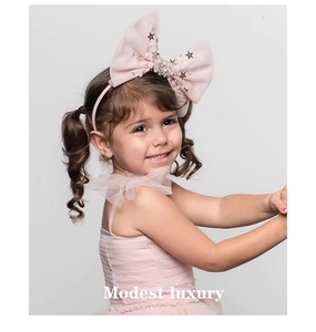 Détail d'un serre-tête nœud tutu rose pour enfants avec étoiles et perles blanches