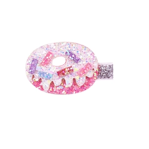Détail de la pince à cheveux donut à paillettes roses avec glaçage blanc pour filles