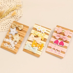 Détail d'un lot de bandeaux en nylon avec nœuds et fleurs brodés pour bébé fille