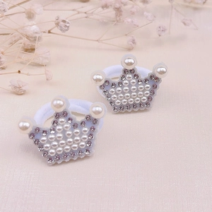 Détail de deux chouchous couronne avec perles blanches et strass violets pour enfants