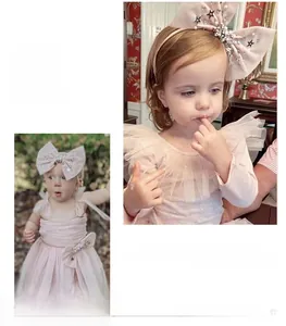 Détail d'une robe tutu rose et bandeau à gros nœud pailleté avec perles et étoiles