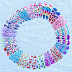 Detailed top view of various colorful teardrop metal snap hair clips for kids in a circle