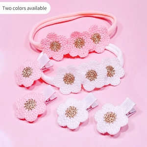 Détail de bandeaux et pinces à fleurs crochetées pour bébés en rose et blanc