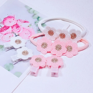 Détail de bandeaux et pinces fleurs au crochet pour bébé avec protection en tissu doux