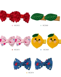 Detailed view of knitted fabric hair clips with floral, leaf, and fruit patterns for girls