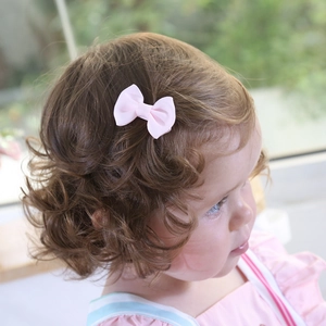 Gros plan d'une barrette noeud rose pour tout-petit pour coiffer les cheveux fins