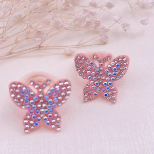 Detailed macro view of butterfly hair ties with sparkling pink rhinestones and elastic bands