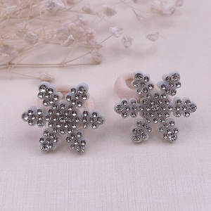 Detailed view of pink snowflake hair ties featuring sparkling rhinestones and elastic cords
