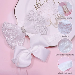 Detailed view of baby white lace hairbands with elegant pearls and embroidery textures