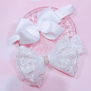 Detail of white lace bow headband with faux pearls and satin ribbon hair accessories
