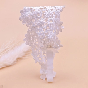 Close-up of white floral lace headband with embroidery and satin bow detail