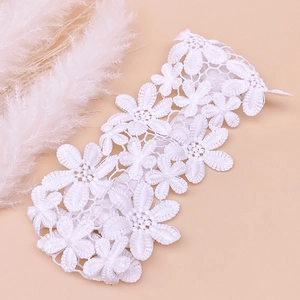 Detailed macro view of white lace floral headbands with intricate embroidered daisy petals