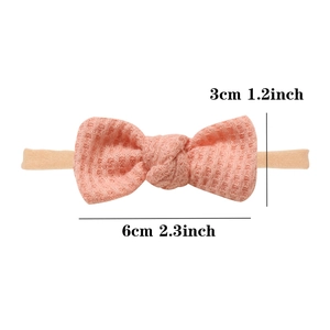 Pink waffle knit infant headband featuring a soft handmade bow and elastic nylon band