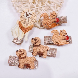 Detail view of five embroidered animal hair clips including lion, squirrel and dog for kids