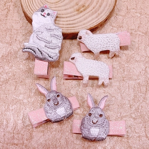 Detailed view of animal embroidery hair clips featuring cats and rabbits with pink glitter