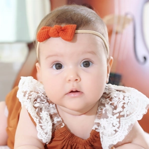 Detail of infant waffle texture bow headband with elastic nylon band on baby model