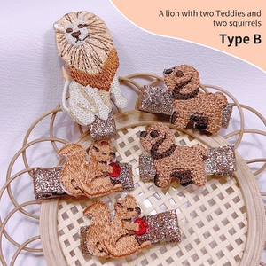 5-piece set of embroidered animal hair clips including lion, teddy, and squirrels on pink glitter