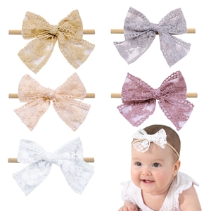 Detail view of baby lace bow headbands in five colors with floral embroidery and soft elastic