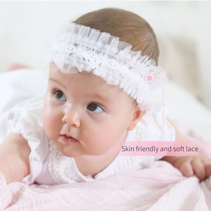 Détail du bandeau en dentelle blanche pour bébé avec un design en tulle doux multicouche