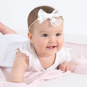 Close-up of white lace bow headband with soft high-elastic band for newborn babies