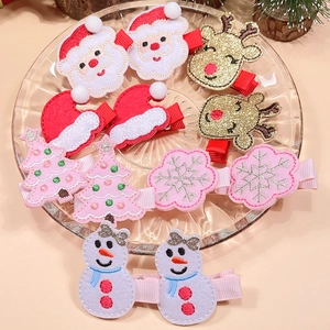 Close-up of festive embroidered Christmas hair clips featuring Santa and reindeer designs