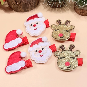 Detail of Christmas hair clips featuring Santa, reindeer, and hats with sequins and fabric