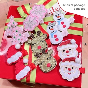 Detail showing 12-piece Christmas hair clip set with reindeer and snowflake motifs
