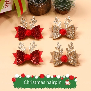 Détail de pinces à cheveux bois de renne pailletées avec nœuds et pompons rouges